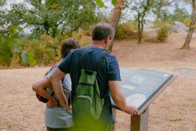 Des randonneurs lisant un panneau d'interprétation le long d'une randonnée